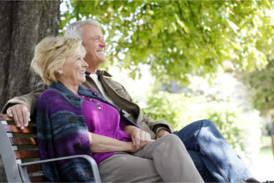 elderly couple sitting in the bench outside